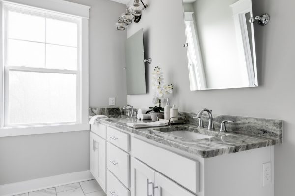 Dual vanity and white cabinetry in bathroom by Richmond Hill Design-Build