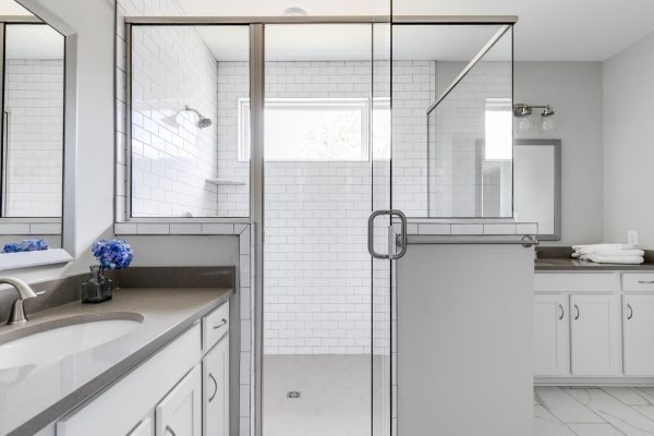 Corner shower with subway tile in owner's suite by Richmond Hill Design-Build