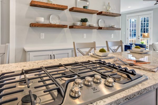 Gas cooktop and floating wood shelving in beautiful home by Richmond Hill Design-Build