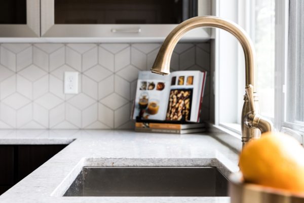 Gorgeous kitchen with gold faucet in new contemporary home by Richmond Hill Design-Build