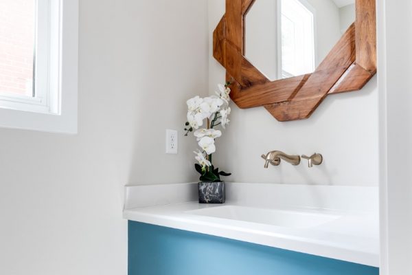 Beautiful powder room with unique mirror in new contemporary home by Richmond Hill Design-Build