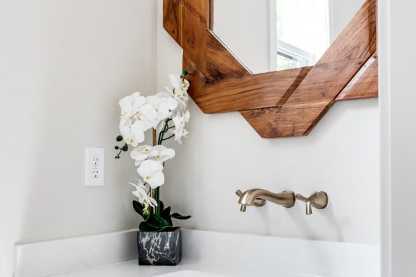 Beautiful powder room with unique mirror in new contemporary home by Richmond Hill Design-Build