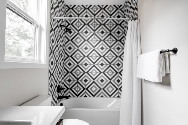 Guest bathroom with tile shower wall in new contemporary home by Richmond Hill Design-Build