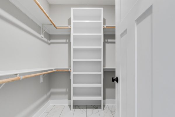 Owner's walk in closet with built in shelving in renovated home by Richmond Hill Design-Build