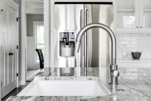 Farmhouse sink and chrome faucet in kitchen in home built by Richmond Hill Design-Build