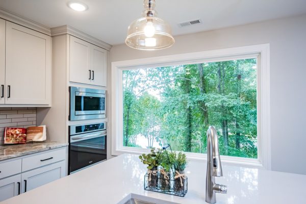 Huge, picture window in gorgeous kitchen with island in renovated ranch home on Lake Cherokee by Richmond Hill Design-Build