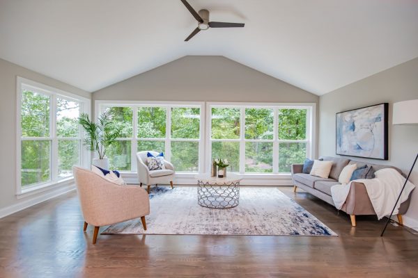 Family room with wall of windows overlooking lake in renovated ranch home by Richmond Hill Design-Build