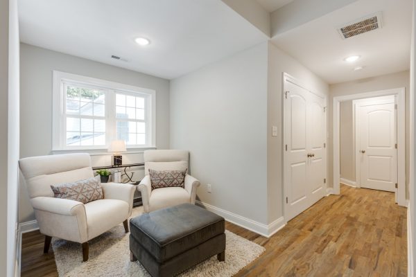 Owner's bedroom with sitting area in renovated home by Richmond Hill Design-Build