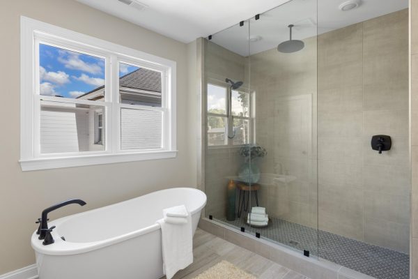 Shower and freestanding tub in primary bathroom of beautiful remodeled home by Richmond Hill Design-Build